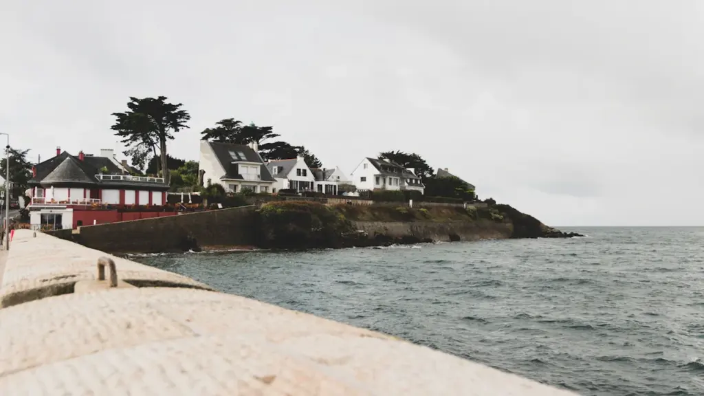 Maisons traditionnelles en bord de mer breton près de Brest avec digue en pierre.