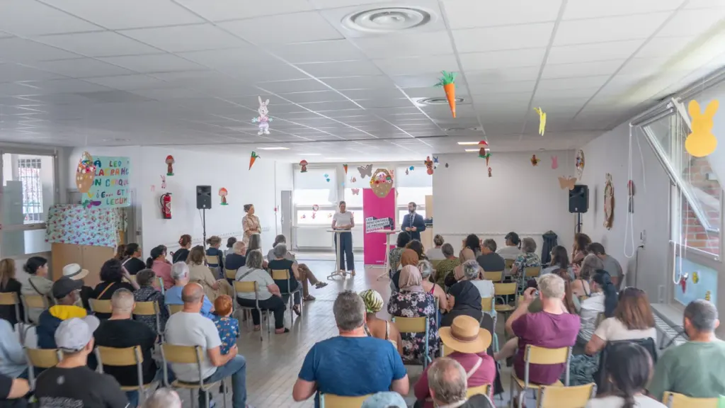 Une assemblée de personnes assises dans une salle écoutant des intervenants lors d'une conférence.