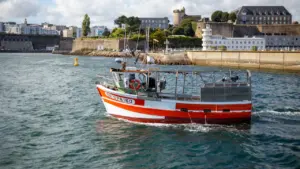Un bateau de pêche naviguant dans le port de Brest, ville portuaire bretonne.