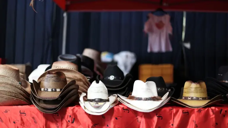 Plusieurs chapeaux de cowboy disposés sur une table pour un événement western à Ermont.