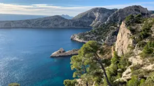 Vue aérienne des calanques de Marseille avec rochers escarpés et mer turquoise.