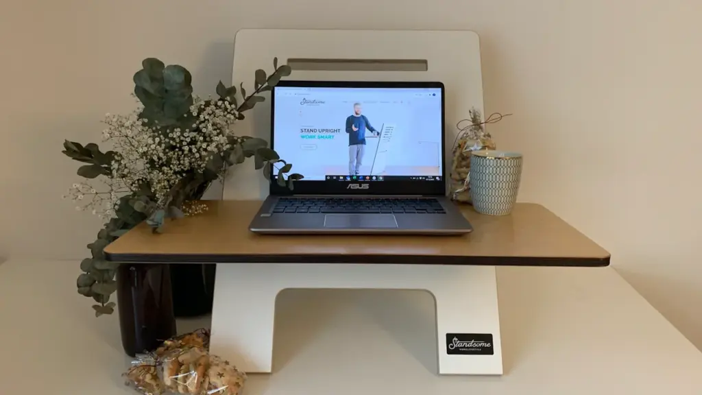 Ordinateur portable ouvert sur un bureau en bois clair dans un environnement de travail.