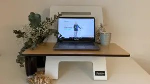 Ordinateur portable ouvert sur un bureau en bois clair dans un environnement de travail.