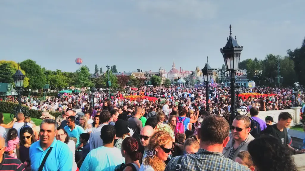 Grande foule rassemblée en extérieur pour une fête publique sous un ciel bleu.