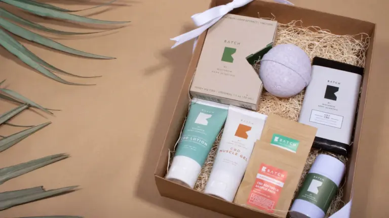 Une boîte cadeau en carton contenant divers produits de soins corporels et compléments au CBD.