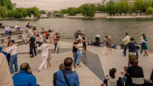 Des personnes dansent en plein air sur les quais de Seine à Paris.