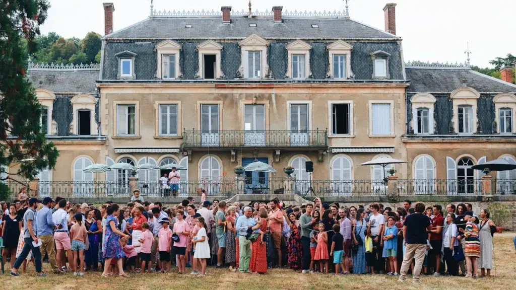 Une foule devant un château traditionnel français lors des Fêtes de la Vigne.