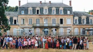 Une foule devant un château traditionnel français lors des Fêtes de la Vigne.