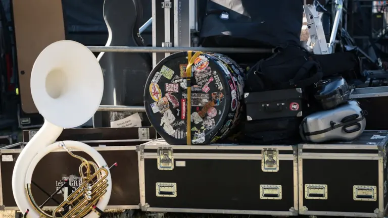 Matériel de musique et instruments rangés dans des caisses sur scène.