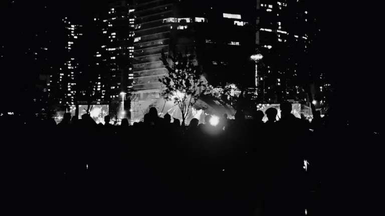 Vue nocturne en noir et blanc d'une foule rassemblée pour un événement urbain