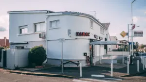 Bâtiment blanc avec une enseigne Tabac typique d'une petite commune française