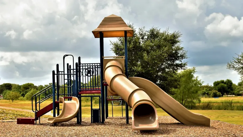 Une aire de jeux pour enfants avec toboggans dans un parc public vide.