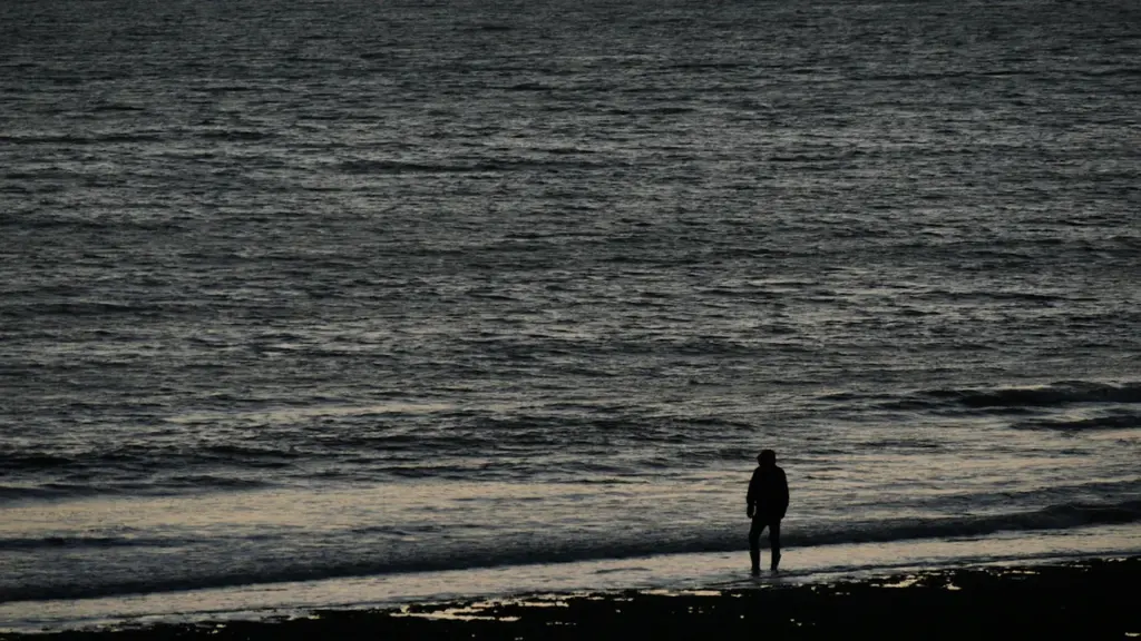 Une silhouette solitaire sur le rivage d'une plage à La Rochelle en France.