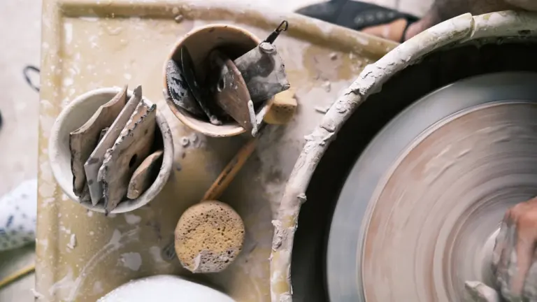Gros plan sur un tour de potier avec des outils en argile artisanale.