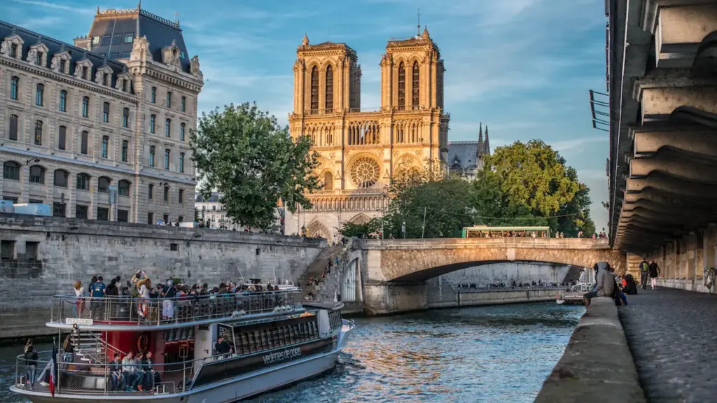 Bateau naviguant sur une rivière calme entouré d'architecture traditionnelle en France
