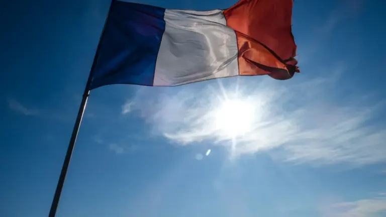 Le drapeau tricolore français flottant fièrement sous un soleil éclatant d'été.