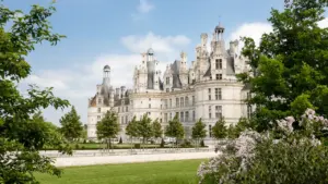 Château majestueux entouré d'arbres verdoyants, cadre idéal pour une soirée de spectacle à Saint-Étienne.