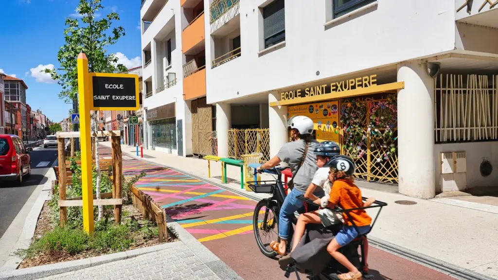Famille à vélo devant l'école Saint-Exupéry, symbole de la rentrée scolaire à Vitry.