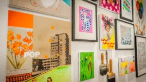 Mur rempli de diverses œuvres d'art encadrées et pinceaux d'artistes dans un atelier.