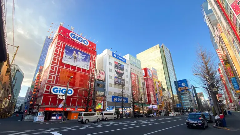 Vue urbaine d'une rue animée avec des bâtiments commerciaux sous un ciel bleu.