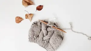 Bonnet en laine tricoté à la main sur un fond blanc épuré.