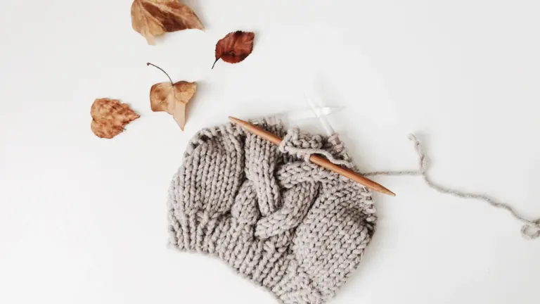 Bonnet en laine tricoté à la main sur un fond blanc épuré.