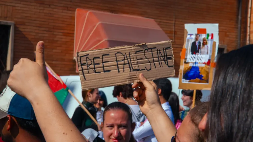 Manifestants lors d'un rassemblement de soutien à la Palestine avec des pancartes militantes.