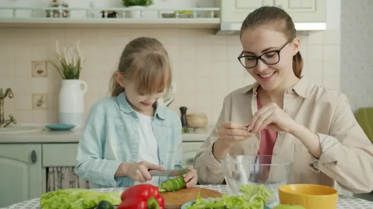Une mère et sa fille préparent ensemble un repas dans leur cuisine familiale.