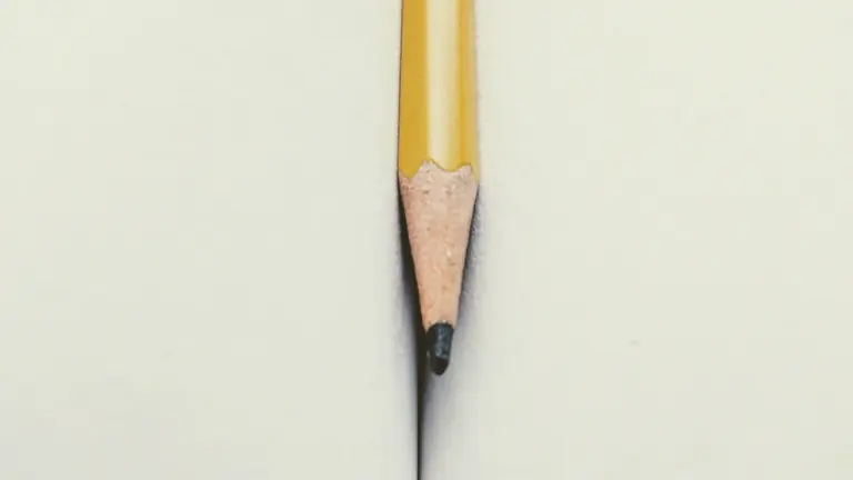 Un crayon jaune bien taillé posé entre les pages d'un livre ouvert.