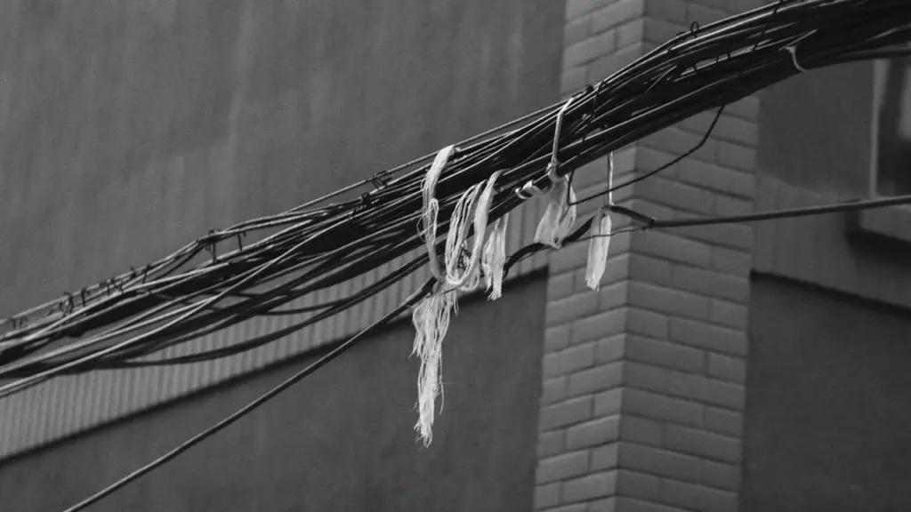 Poteau électrique avec des câbles emmêlés sur un fond de ciel clair.