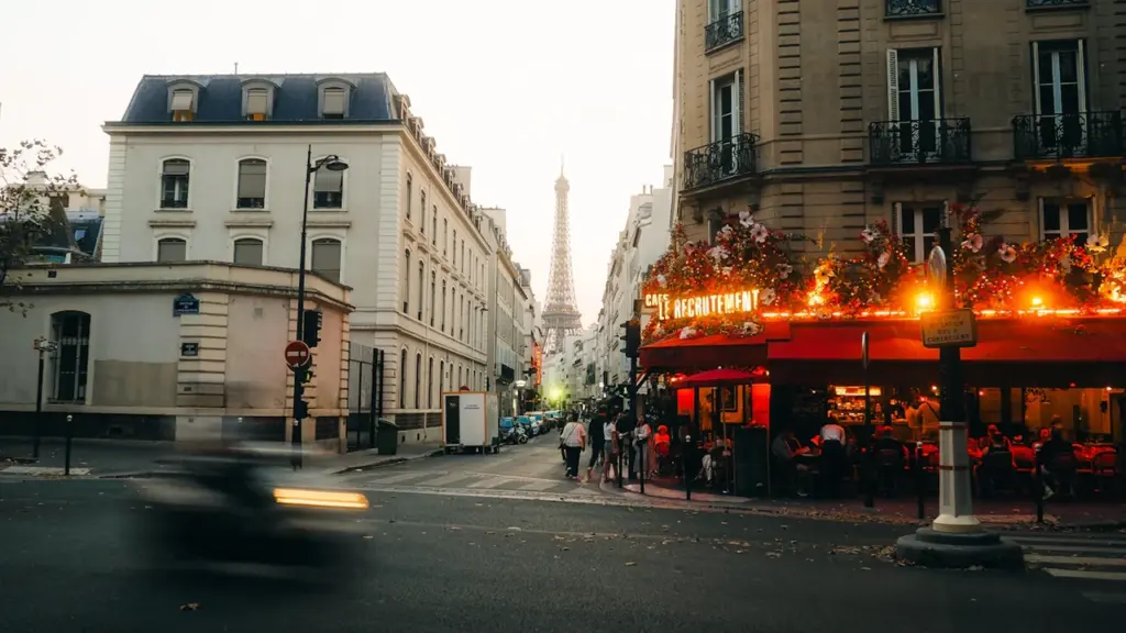 Une terrasse de café parisienne animée lors d'une journée ensoleillée de printemps.