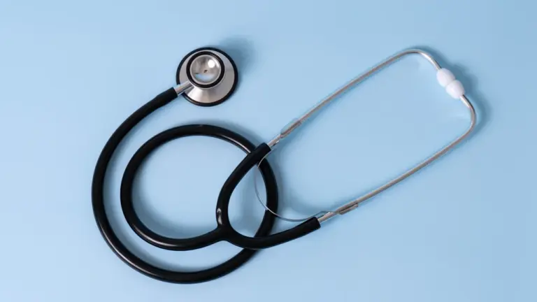 Un stéthoscope médical posé sur un fond bleu pastel uniforme.