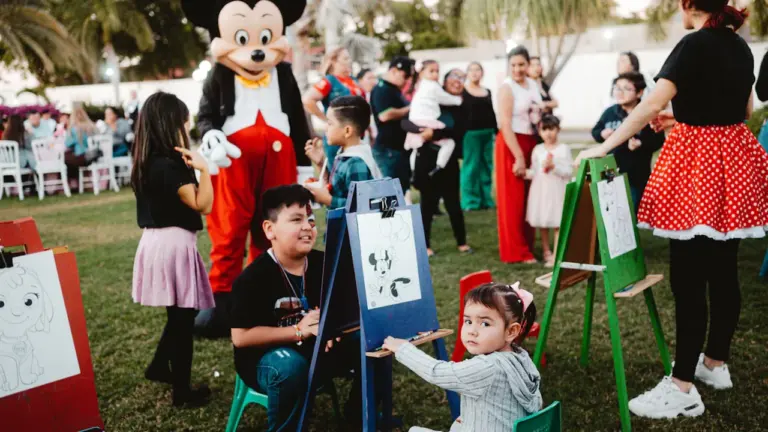 Enfants participant à des activités ludiques et artistiques lors d'une fête en plein air.