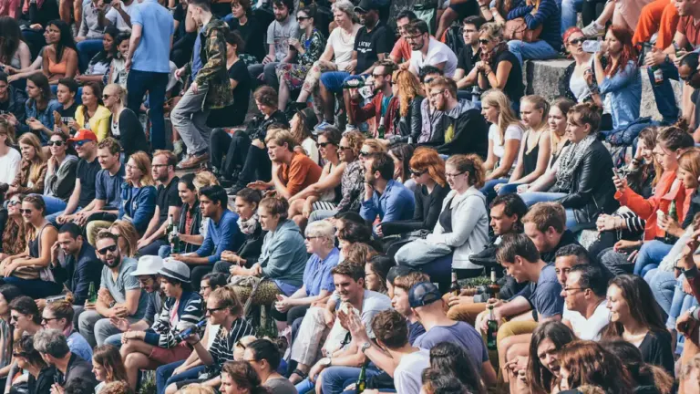 Une foule diversifiée assise dans les gradins d'un stade lors d'un événement en France.