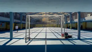 Cage de football sur un terrain de sport scolaire urbain en extérieur.