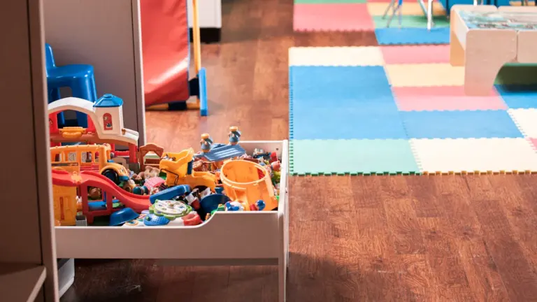 Salle de jeux colorée avec tapis éducatif et jouets pour les jeunes enfants.