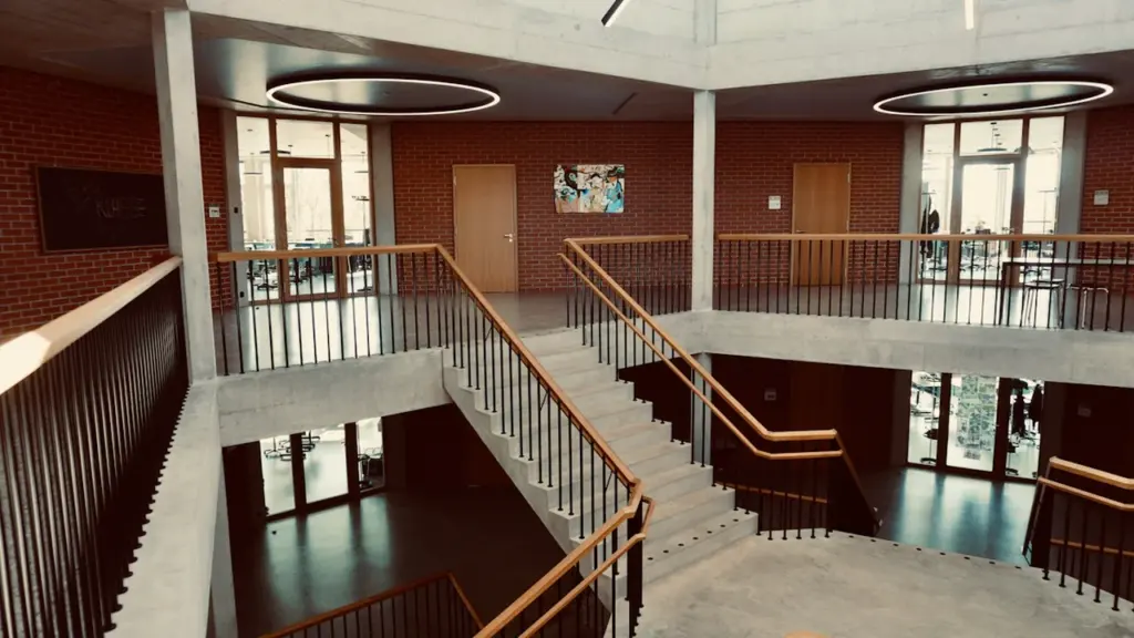 Architecture moderne d'une école avec un escalier en colimaçon et murs en briques.