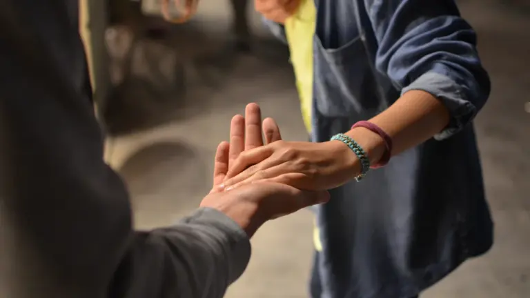 Deux mains se rejoignant, symbolisant la solidarité et l'entraide entre les personnes.